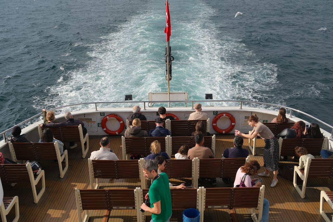 A diverse group of people enjoy a sunlit boat ride, showcasing movement and leisure.